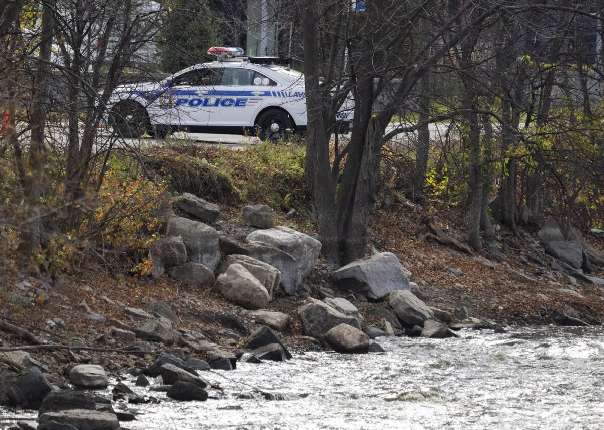 Police seal off the site where a missing one-month-old baby was found after a car crashed into the water of the Milles Iles River three days ago, in Laval, Que., Oct. 31, 2022. (The Canadian Press/Ryan Remiorz)