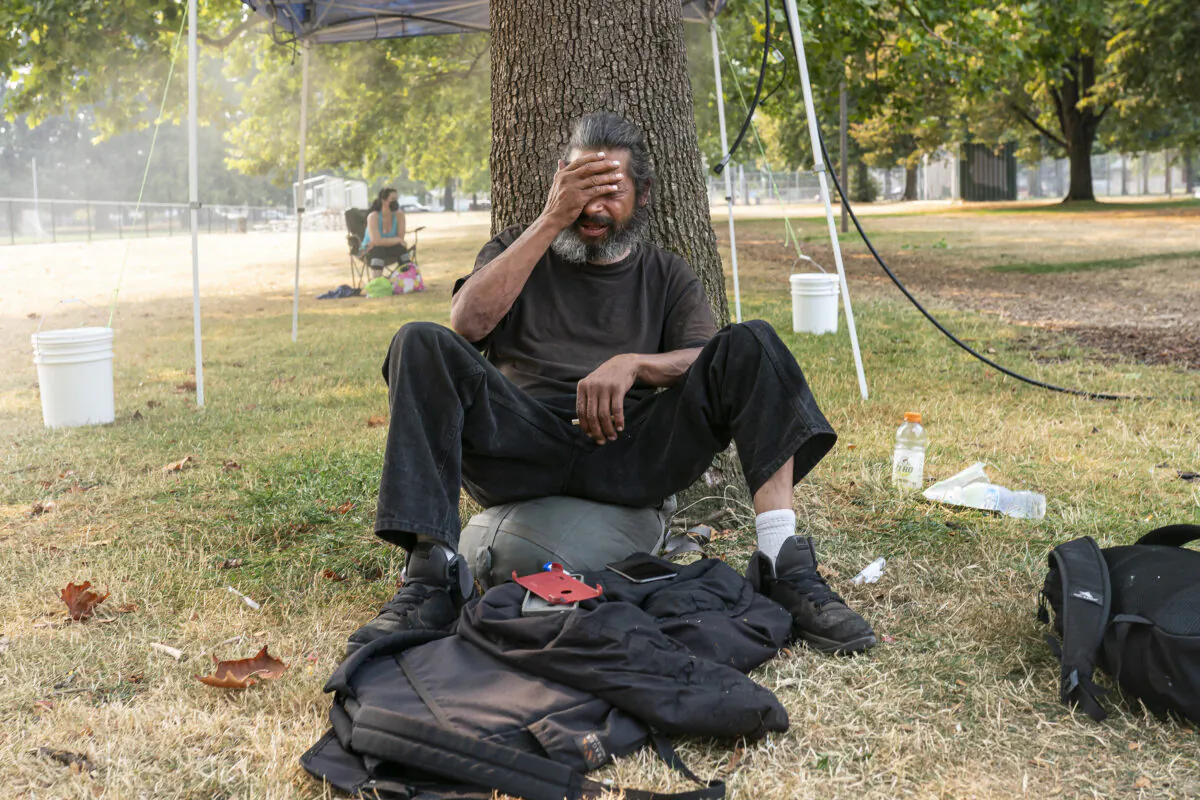 A homeless man, who asked to not be named, tries to stay cool near a misting station in Lents Park during an extreme heat wave in Aug. 13, 2021, in Portland, Ore. As temperatures climb across the nation, nearly 200 million Americans are under some level of heat advisory. (Nathan Howard/Getty Images)