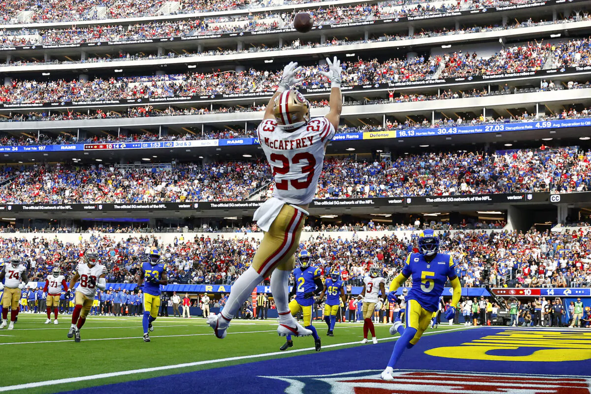Christian McCaffrey (23) of the San Francisco 49ers catches the ball for a touchdown as Jalen Ramsey (5) and Taylor Rapp (24) of the Los Angeles Rams defend during the third quarter at SoFi Stadium in Inglewood, Calif., on Oct. 30, 2022. (Ronald Martinez/Getty Images)