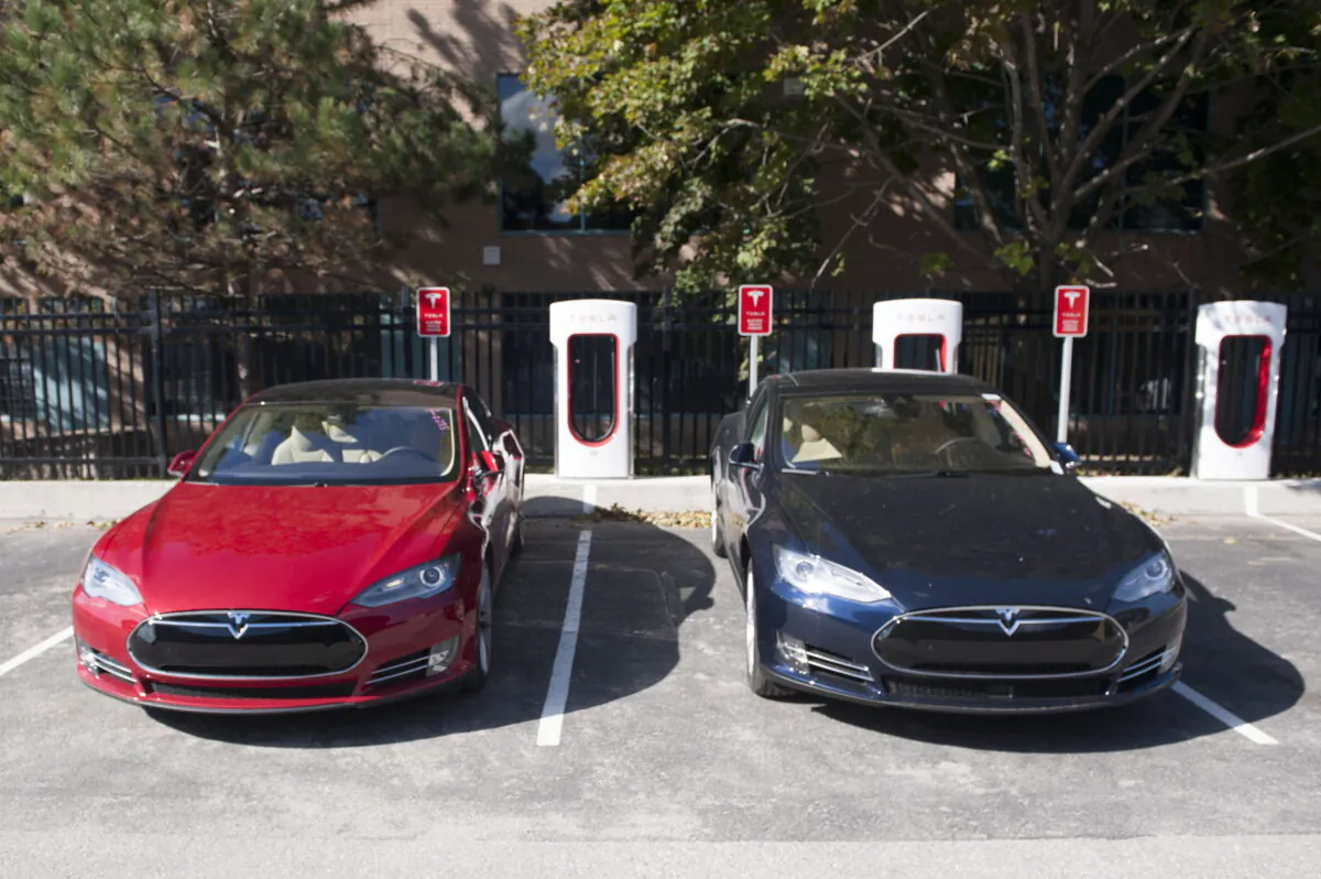 Two Tesla model cars are charged by a Tesla supercharger at Tesla Motors in Toronto on Oct. 10, 2014. (Hannah Yoon/The Canadian Press)