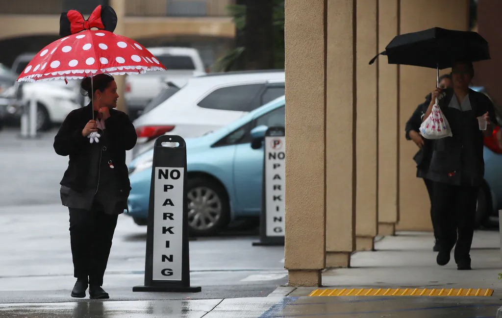 A hotel worker walks near the famed Disneyland amusement park in Anaheim, Calif., on March 13, 2020. (Mario Tama/Getty Images)