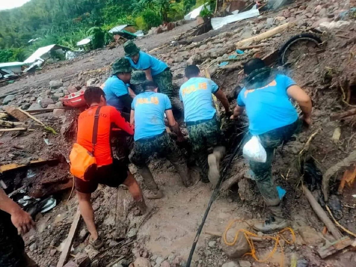 Philippine Coast Guard (PCG) and Philippine National Police (PNP) rescuers retrieve a body following flooding and landslides due to Tropical Storm Nalgae, in Datu Odin Sinsuat, Maguindanao, Philippines, on Oct. 28, 2022. (Philippine Coast Guard/Handout via Reuters)