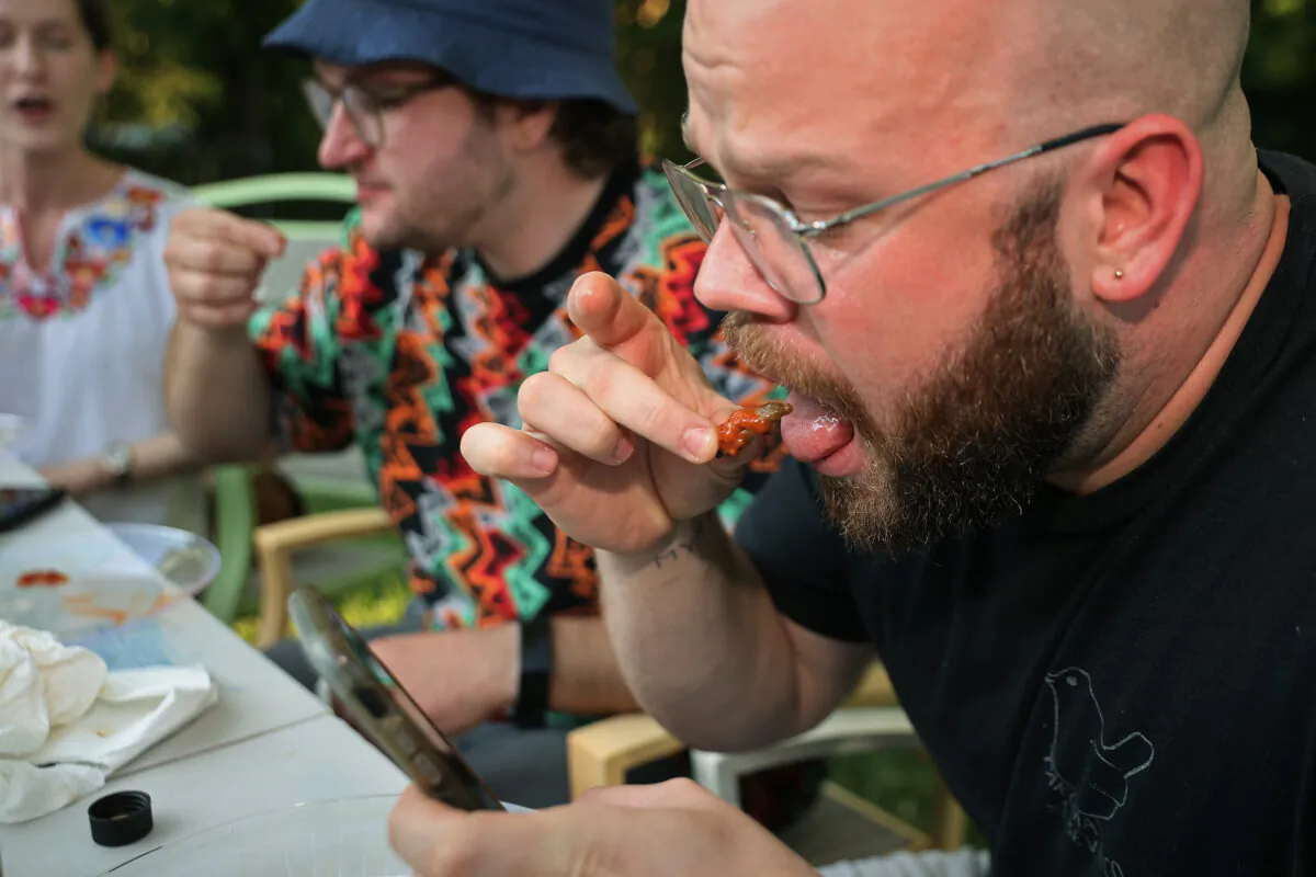 People eat periodical cicadas in Hyattsville, Maryland, on June 4, 2021. (Chip Somodevilla/Getty Images)