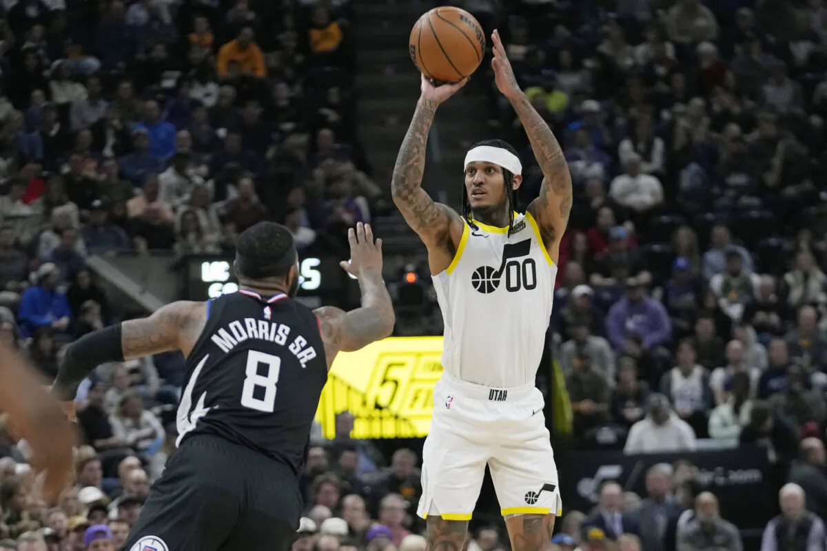 Utah Jazz guard Jordan Clarkson (0) shoots as Los Angeles Clippers forward Marcus Morris Sr. (8) defends during the first half of an NBA basketball game in Salt Lake City, on Nov. 30, 2022. (Rick Bowmer/AP Photo)