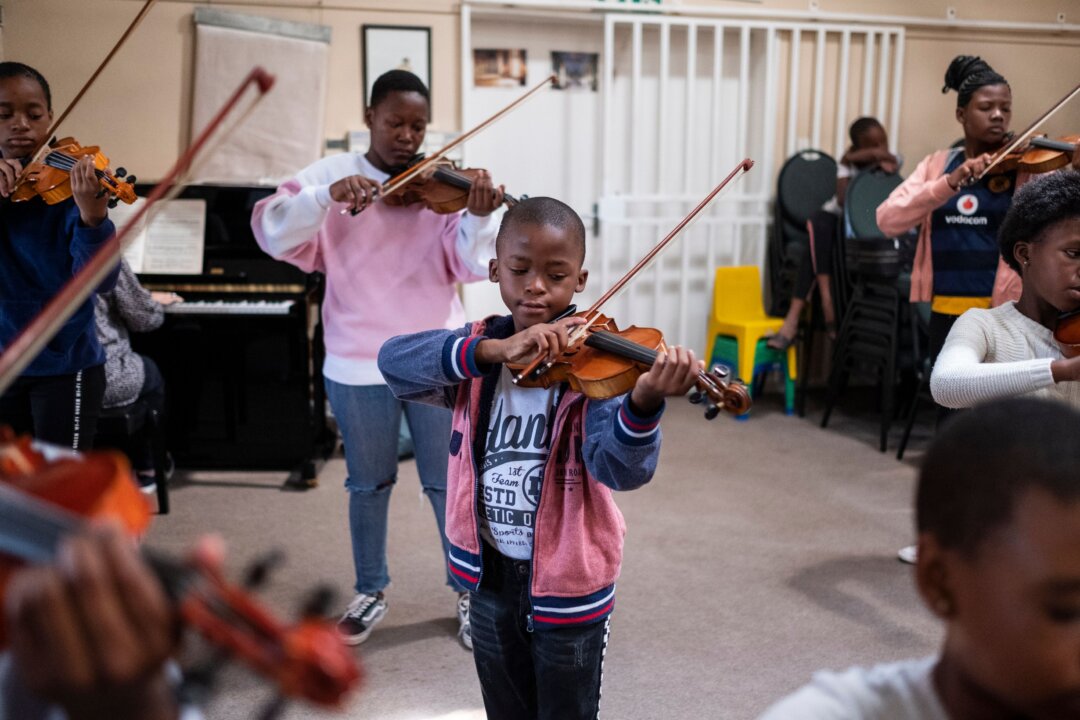 A young child plays the violin during a lesson with Buskaid at the Reformed Presbyterian Church in Diepkloof, Soweto, on April 13, 2019. (Wikus de Wet/Getty Images)
