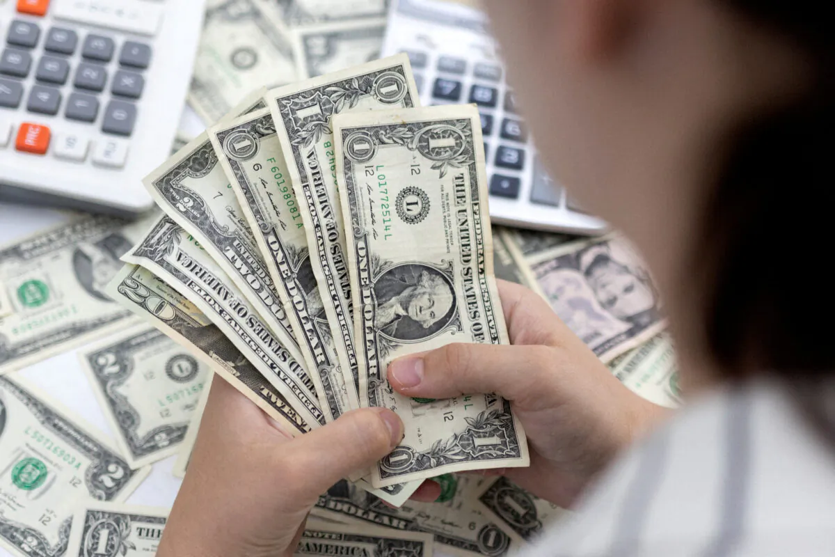Woman holds U.S. bank notes, on May 30, 2022. (Dado Ruvic/Illustration/Reuters)