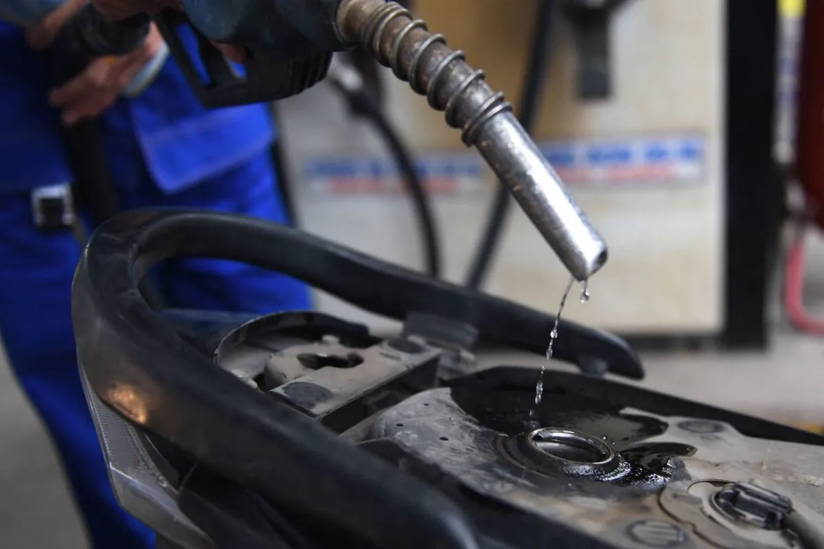 A gas station employee pumps gasoline into the petrol tank of a customer's motorcycle in Hanoi on March 10, 2022. (Nhac Nguyen/AFP via Getty Images)
