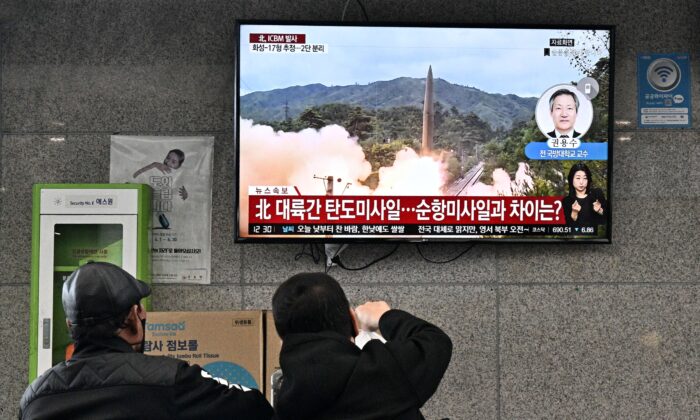 2022 年 11 月 3 日，游客在韩国东部岛屿郁陵岛的渡轮码头观看新闻广播，播放朝鲜导弹试验的文件镜头。法新社） 