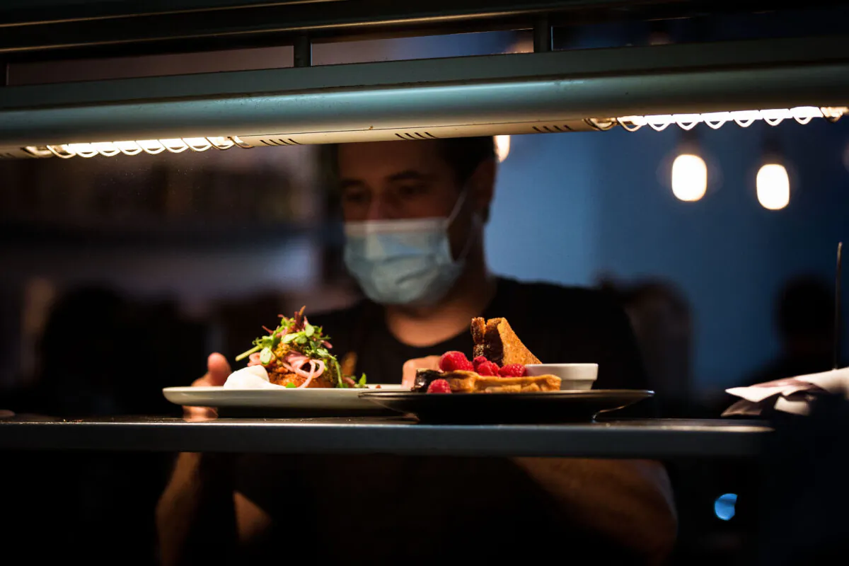 Staff at Lux Cafe serve food in Melbourne, Australia, on Oct. 22, 2021. (Darrian Traynor/Getty Images)