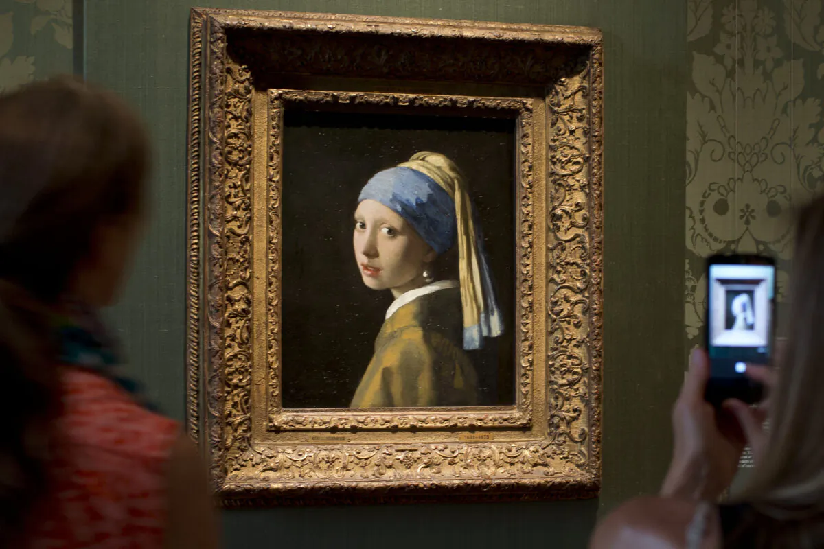 Visitors take pictures of Johannes Vermeer's Girl with a Pearl Earring (approx. 1665) during a preview for the press of the renovated Mauritshuis in The Hague, Netherlands on June 20, 2014. (Peter Dejong/AP Photo)