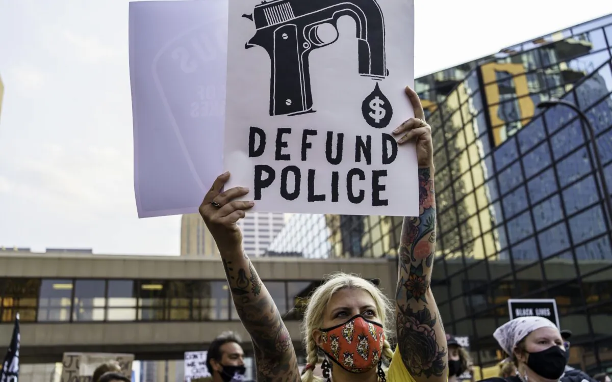 A protestor holds a sign reading “Defund the Police” outside Hennepin County Government Plaza during a demonstration against police brutality and racism, in Minneapolis, on Aug. 24, 2020. (Kerem Yucel/AFP/Getty Images)