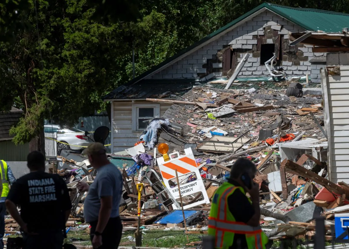 Multiple agencies investigate the scene the morning after a house explosion in the 1000 block of North Weinbach Avenue in Evansville, Ind., on Aug. 11, 2022. (MaCabe Brown/Evansville Courier & Press via AP)