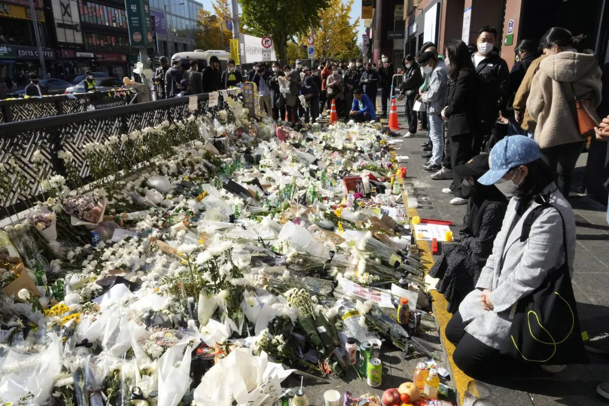 People pay tribute to victims of a deadly crowd crush during Saturday night's Halloween festivities, at a makeshift flower-laying area set up near the scene of the incident in Seoul, South Korea, Nov. 2, 2022. (The Canadian Press/AP-Ahn Young-joon)

