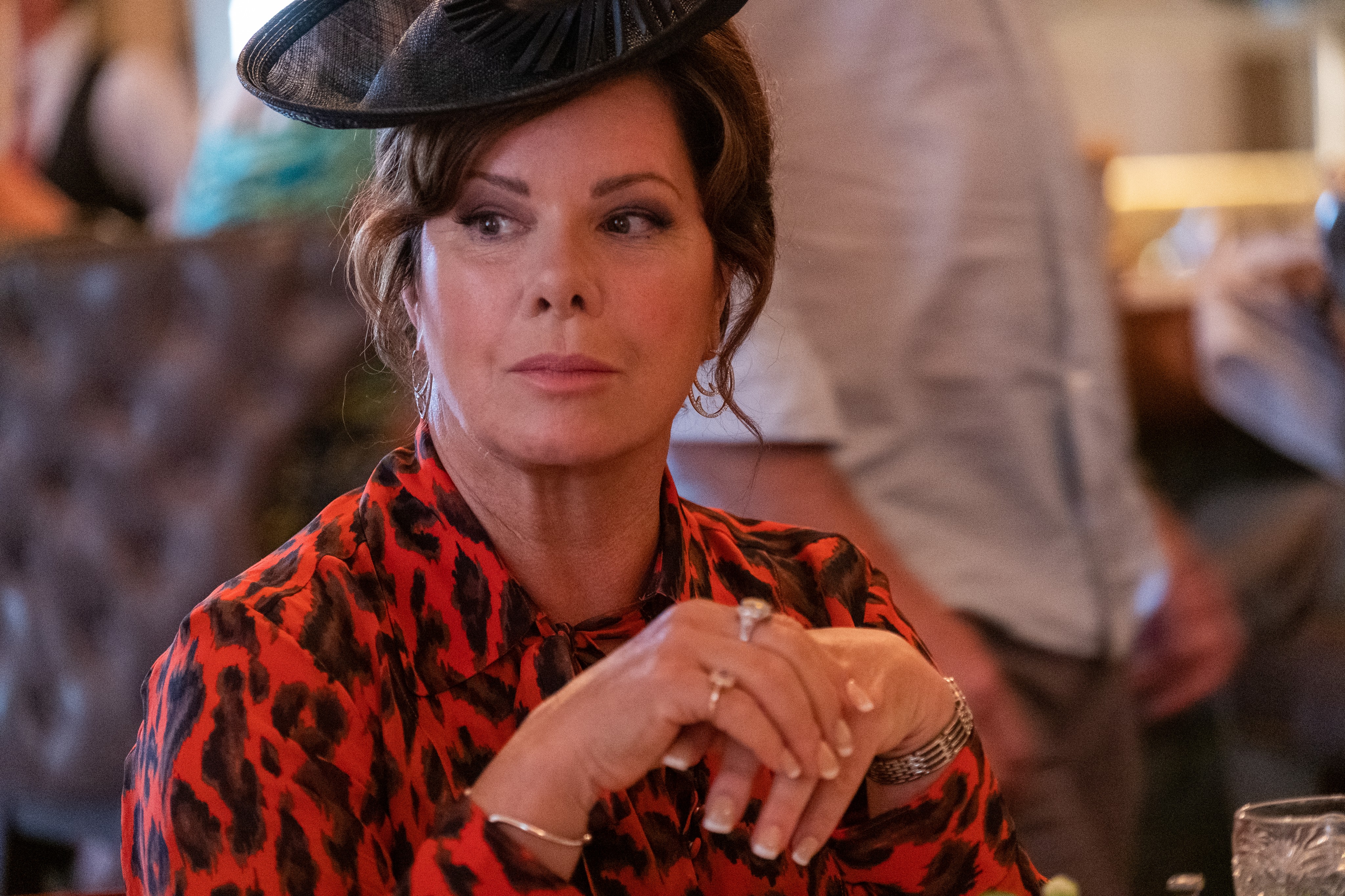 woman in red and black blouse and black hat in Confess, Fletch