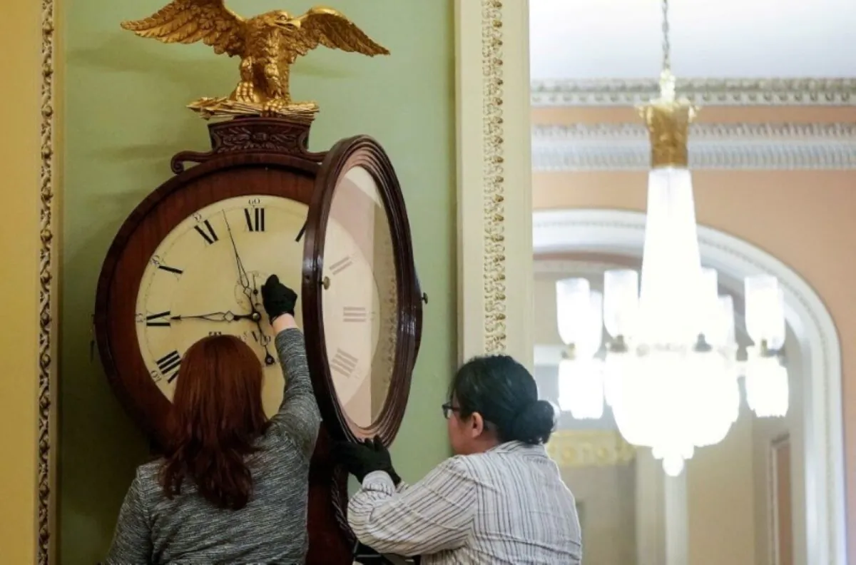 Employees with the Architect of the Capitol wind the Ohio Clock in the U.S. Capitol in Washington on Jan. 21, 2020. (Joshua Roberts/Reuters)