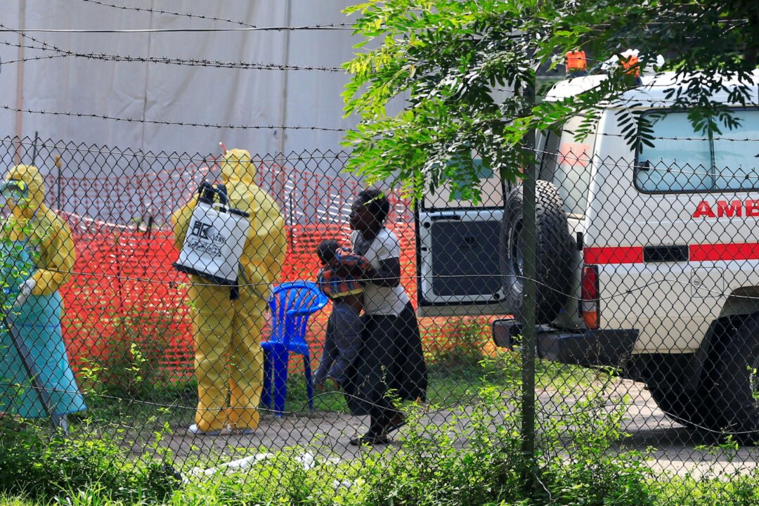 A woman and her child arrive for ebola related investigation at the health facility at the Bwera general hospital near the border with the Democratic Republic of Congo in Bwera, Uganda, on June 14, 2019. (James Akena/Reuters)