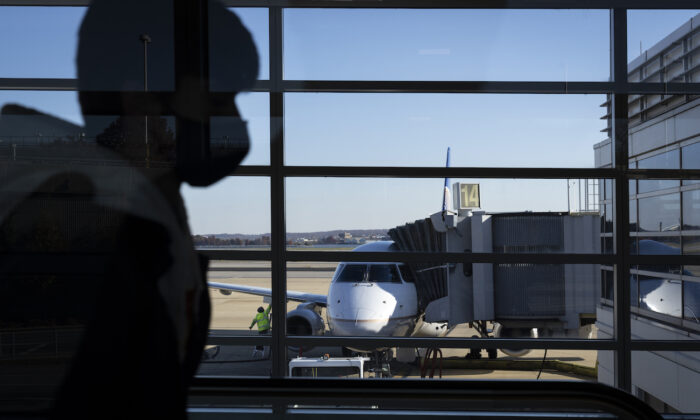 2021 年 11 月 23 日，旅客穿过弗吉尼亚州阿灵顿罗纳德·里根华盛顿国家机场的 A 航站楼。（Drew Angerer/Getty Images）
