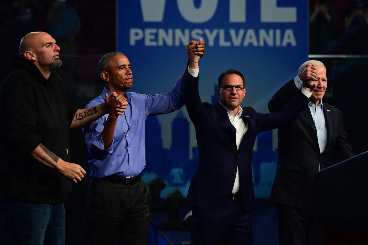 (L-R) Democratic candidate for U.S. Senator John Fetterman, former President Barack Obama, Democratic candidate for Governor Josh Shapiro, and President Joe Biden raise their arms when departing after a rally at the Liacouras Center in Philadelphia on Nov. 5, 2022. (Mark Makela/Getty Images)