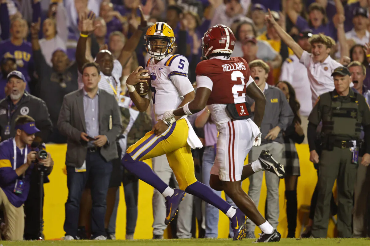LSU quarterback Jayden Daniels (5) runs the ball past Alabama defensive back DeMarcco Hellams (2) to score a two-point conversion during overtime of an NCAA college football game in Baton Rouge, La., on Nov. 5, 2022. (Tyler Kaufman/AP Photo)