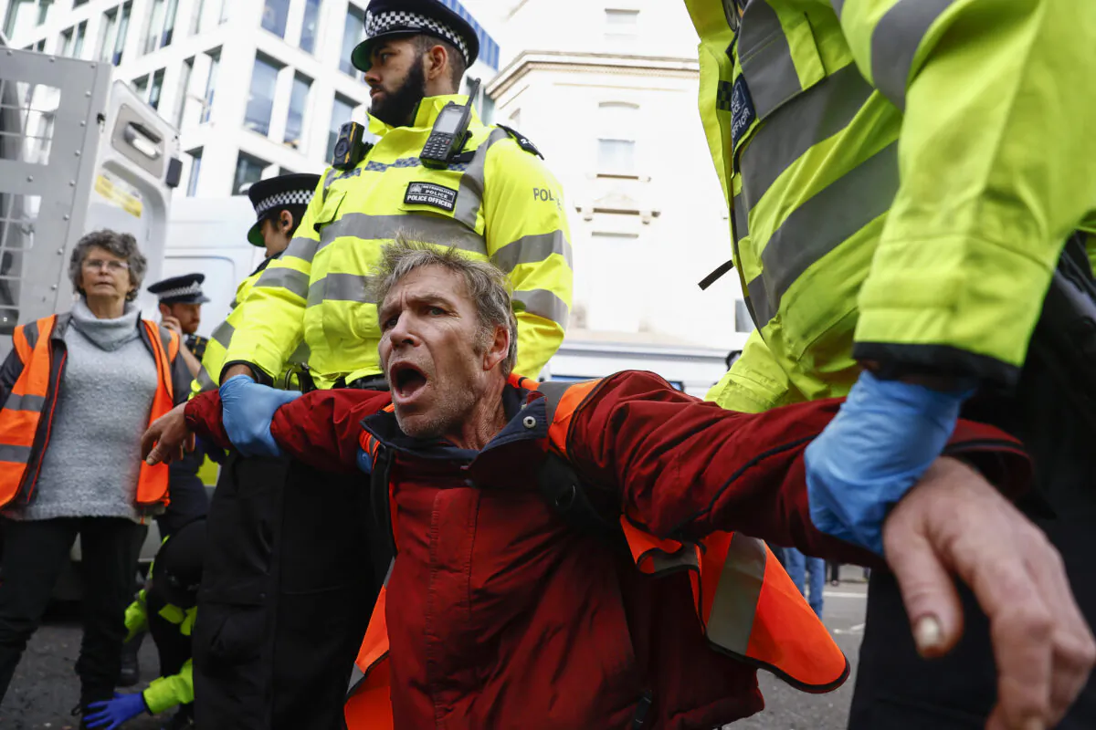 Just Stop Oil protesters are arrested after they blocked the road at the junction of Cannon St. and Queen Victoria St. in London on Oct. 27, 2022. (Jeff J Mitchell/Getty Images)