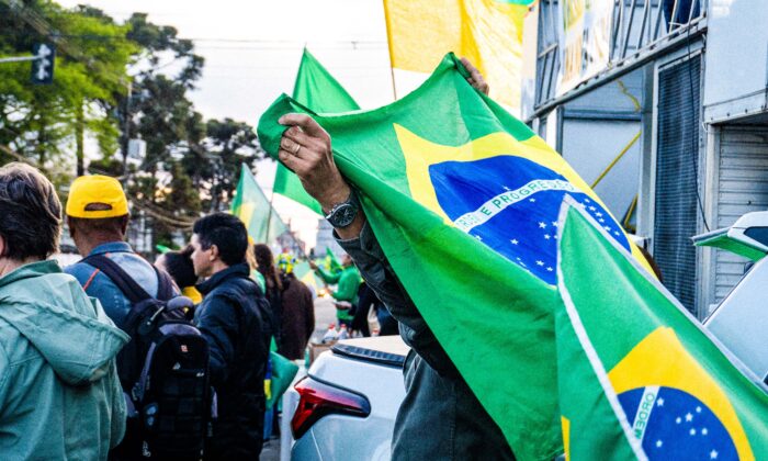 A Brazilian protester holds a flag in Curitiba, Brazil, on November 4, 2022. The country, Latin America’s largest economy, has many taking to the streets, after historical elections spark controversy. (Frederico Vidovix/The Epoch Times)