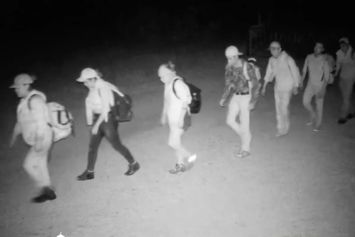 A trail camera captures illegal aliens walking on a rancher's property at night in Kinney County, Texas, in September 2022. (Courtesy of a rancher)
