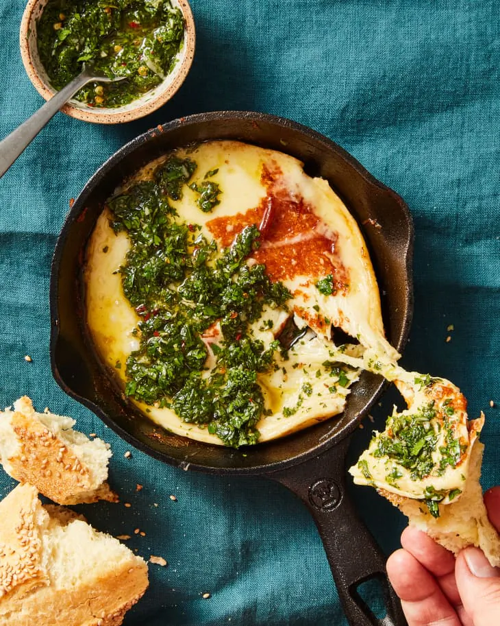 Soft, melty grilled cheese topped with herbaceous chimichurri is a staple appetizer in Argentine cuisine. (Christopher Testani/TNS)