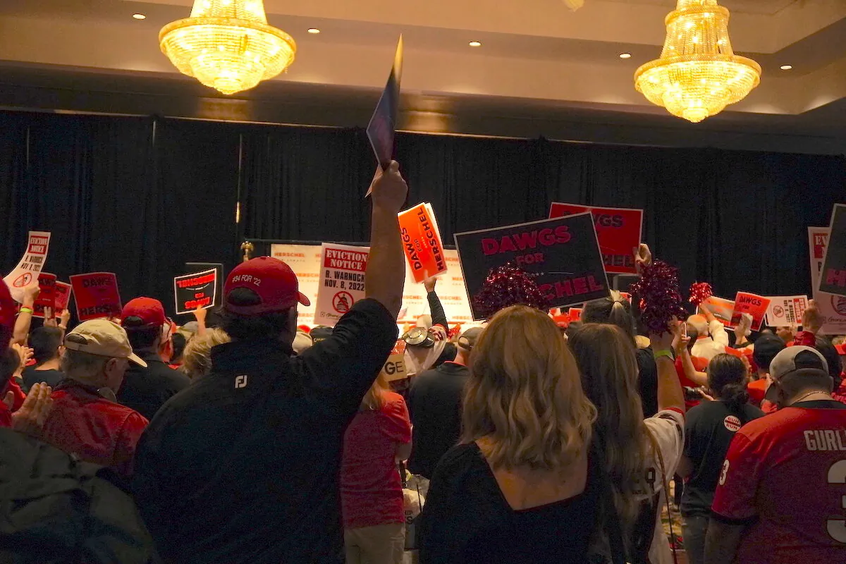 Supporters of Republican Senate candidate Herschel Walker wave signs at a rally in Athens, Ga., on Nov. 5, 2022. (Jackson Elliott/The Epoch Times)