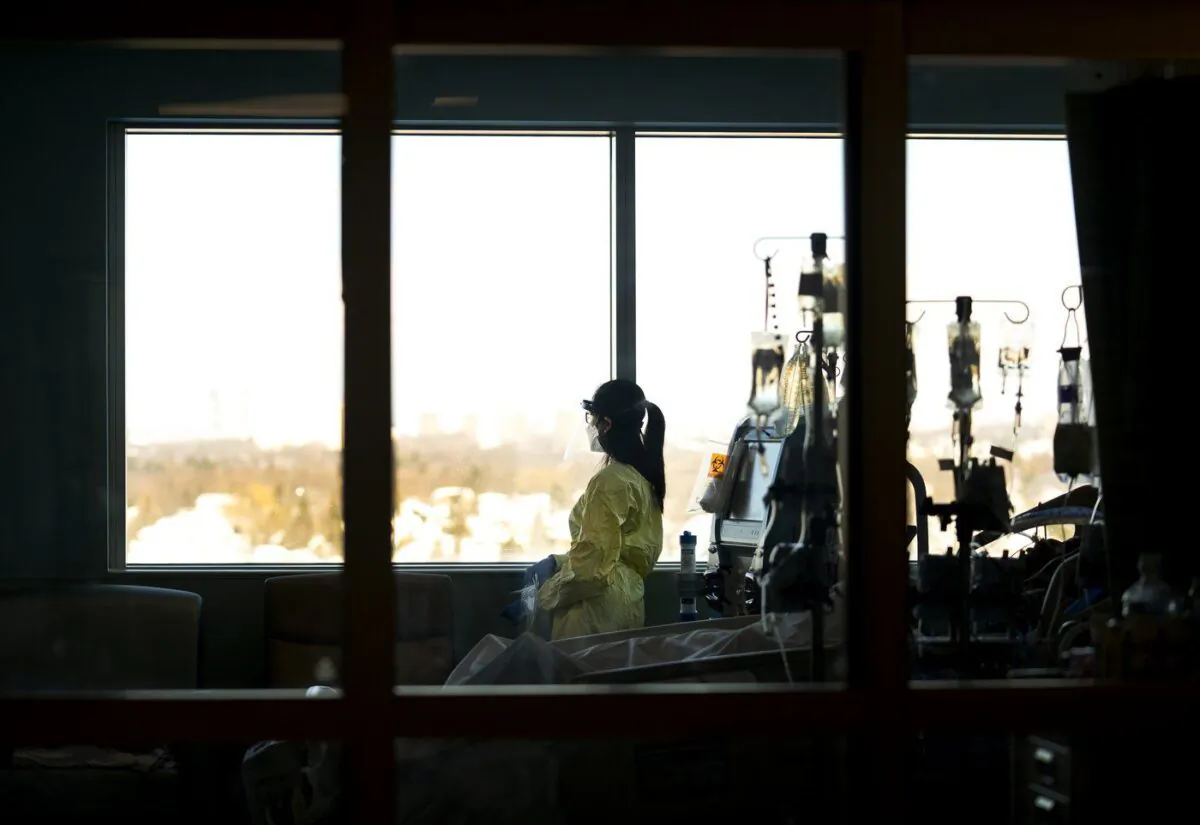 A registered nurse takes a moment to look outside while attending to a ventilated COVID-19 patient in the intensive care unit at the Humber River Hospital, in Toronto, Jan. 25, 2022. (The Canadian Press/Nathan Denette)