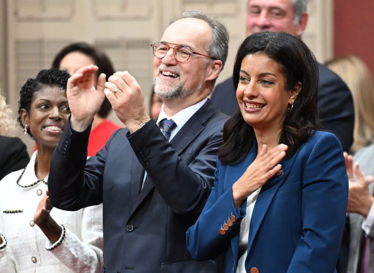 Quebec Liberal Leader Dominique Anglade puts her hand to her heart as she enters with her elected caucus to be sworn in during a ceremony at the legislature in Quebec City, Oct. 18, 2022. (The Canadian Press/Jacques Boissinot)