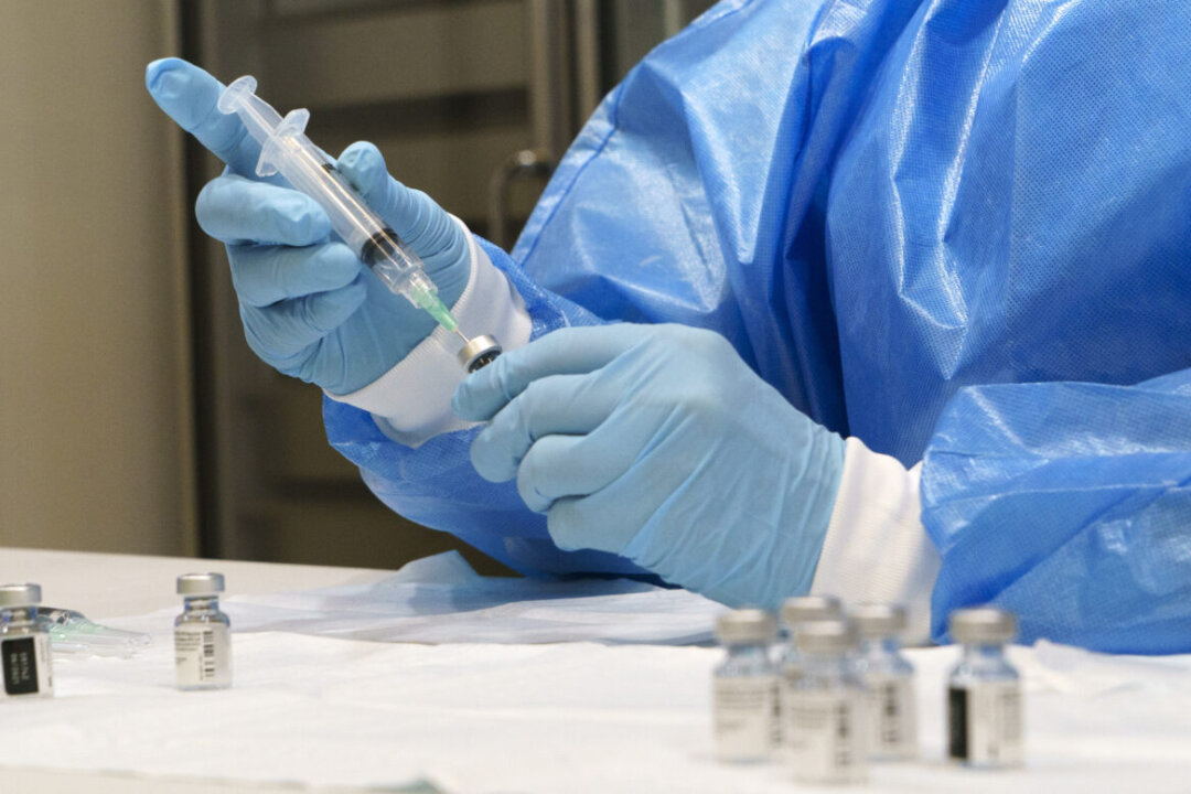 A syringe is prepared with a COVID-19 vaccine at a vaccination clinic in Montreal, Quebec, on March 15, 2021. (The Canadian Press/Paul Chiasson)