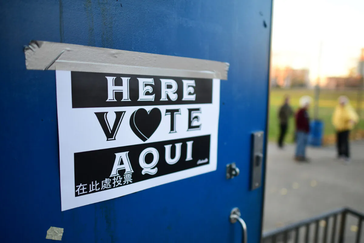 A placard states "HERE VOTE AQUI" as voters wait in line outside the Kendrick Recreation Center polling location as it opens at 7 a.m. on Nov. 8, 2022 in Philadelphia, Pa. (Mark Makela/Getty Images)