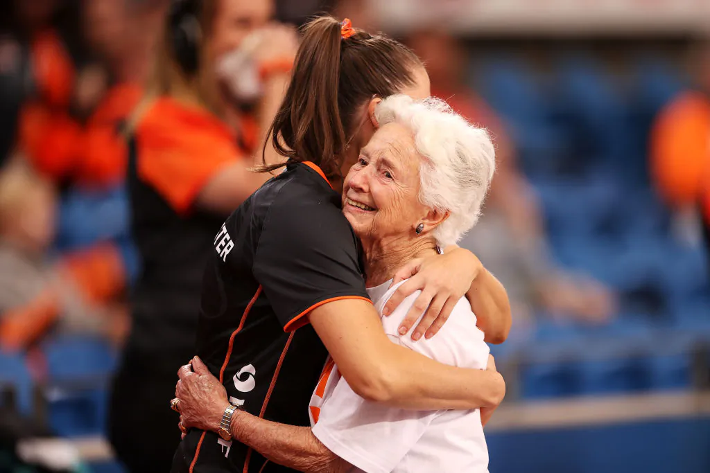 Amy Parmenter of the Giants embraces her grandmother Kathy after entering the court together before the round eight Super Netball match between GWS Giants and NSW Swifts at Ken Rosewall Arena, in Sydney, Australia, on May 8, 2022. (Mark Kolbe/Getty Images)