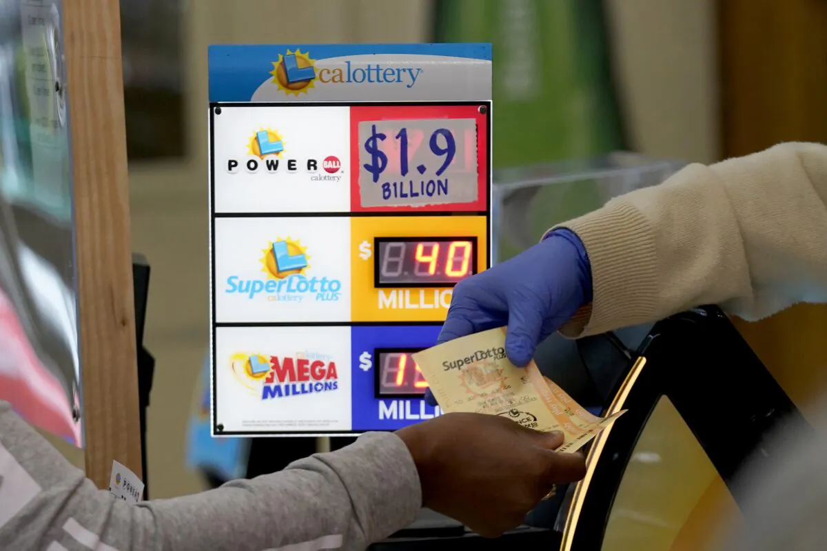 A customer is handed Powerball tickets purchased at Lichine's Liquor & Deli in Sacramento, Calif., on Nov. 7, 2022. (Rich Pedroncelli/AP Photo)
