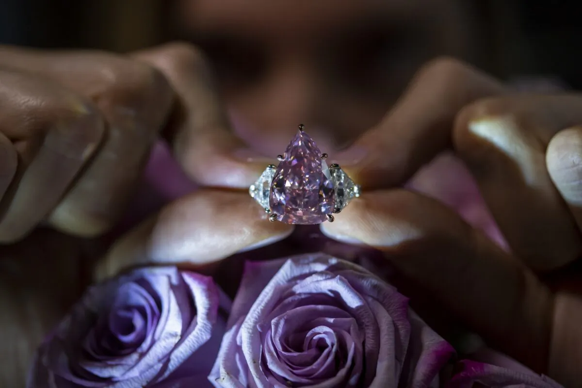 A Christie's employee displays a pink diamond called "The Fortune Pink" of 18,18 carat during a preview at Christie's in Geneva on Nov. 2, 2022. (Martial Trezzini/Keystone via AP)