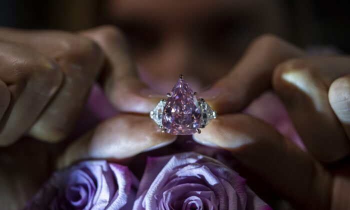 A Christie's employee displays a pink diamond called "The Fortune Pink" of 18,18 carat during a preview at Christie's in Geneva on Nov. 2, 2022. (Martial Trezzini/Keystone via AP)