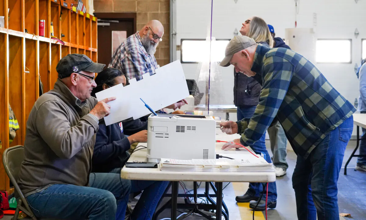 Residents sign up to get their ballots printed out by poll workers at Neversink fire engine company in Port Jervis, N.Y., on Nov. 8, 2022. (Cara Ding/The Epoch Times)