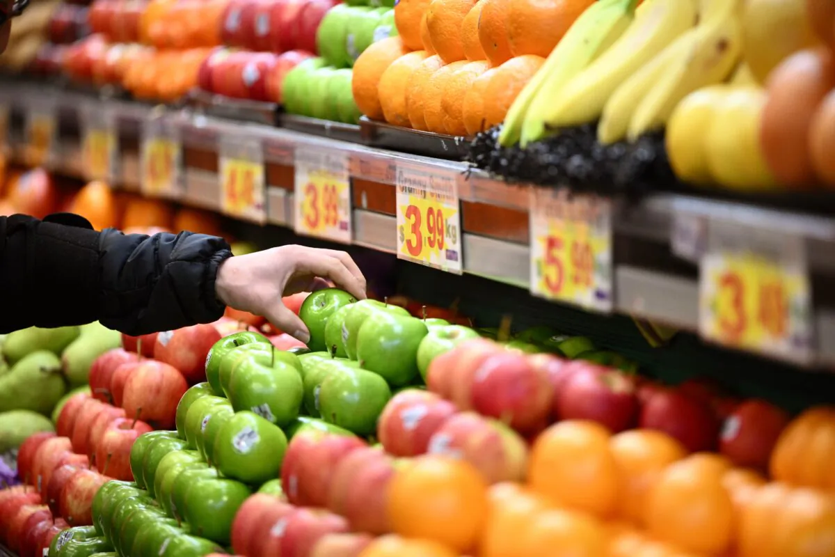 A worker arranges apples for sale at a market in Melbourne, Australia, on July 27, 2022. (AAP Image/Joel Carrett)
