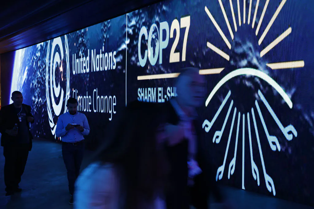 Conference participants walk through an illuminated tunnel at the UNFCCC COP27 climate conference in Sharm El Sheikh, Egypt, on Nov. 8, 2022. (Sean Gallup/Getty Images)