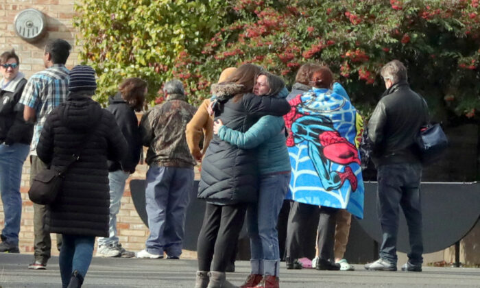 2022 年 11 月 8 日西雅图发生校园枪击事件的报道后，父母在英格拉汉姆高中外互相安慰。（Greg Gilbert/The Seattle Times via AP）