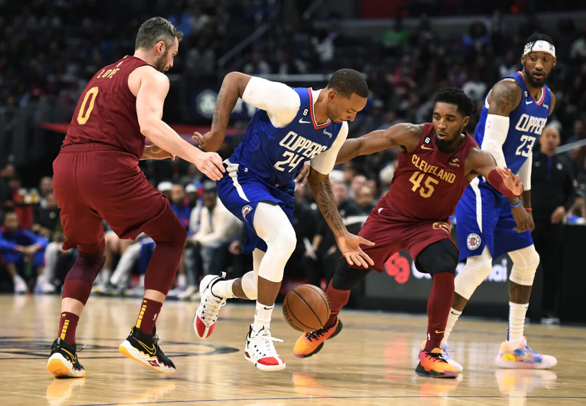 Norman Powell (24) of the Los Angeles Clippers drives to the basket in between Donovan Mitchell (45) and Kevin Love (0) of the Cleveland Cavaliers during the second half at Crypto.com Arena on Nov. 7, 2022. (Kevork Djansezian/Getty Images)