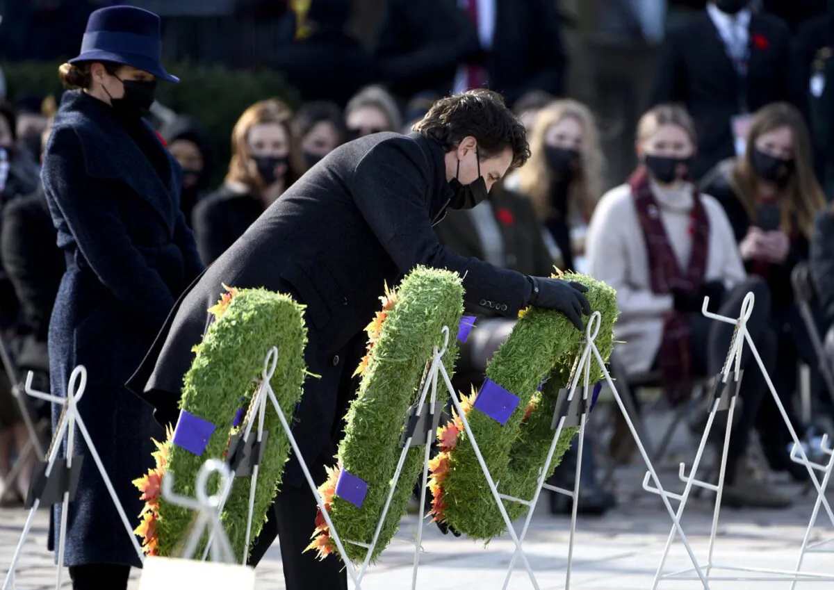 Prime Minister Justin Trudeau is accompanied by his wife Sophie Gregoire Trudeau as he places a wreath at the National War Memorial during the National Remembrance Day Ceremony in Ottawa, on Nov. 11, 2021. (The Canadian Press/Justin Tang)