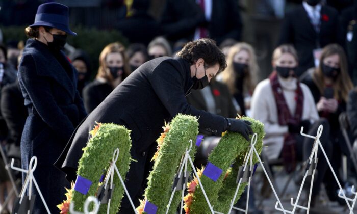 2021 年 11 月 11 日，在渥太华举行的国殇日仪式上，总理贾斯汀·特鲁多在妻子苏菲·格雷瓜尔·特鲁多的陪同下向国家战争纪念馆敬献花圈。（加拿大媒体/贾斯汀·唐）
