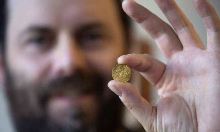 Jamie Brake, Newfoundland and Labrador provincial archeologist, displays a thin English coin at the Confederation Building in St. John's on Nov. 9, 2022. (The Canadian Press/Paul Daly)
