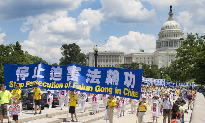 法轮功示威者于 2014 年 7 月 17 日在华盛顿国会山游行，这是法轮大法学会发起的结束中国对法轮功修炼者的迫害活动的一部分。  （吉姆沃森/法新社通过盖蒂图片社）