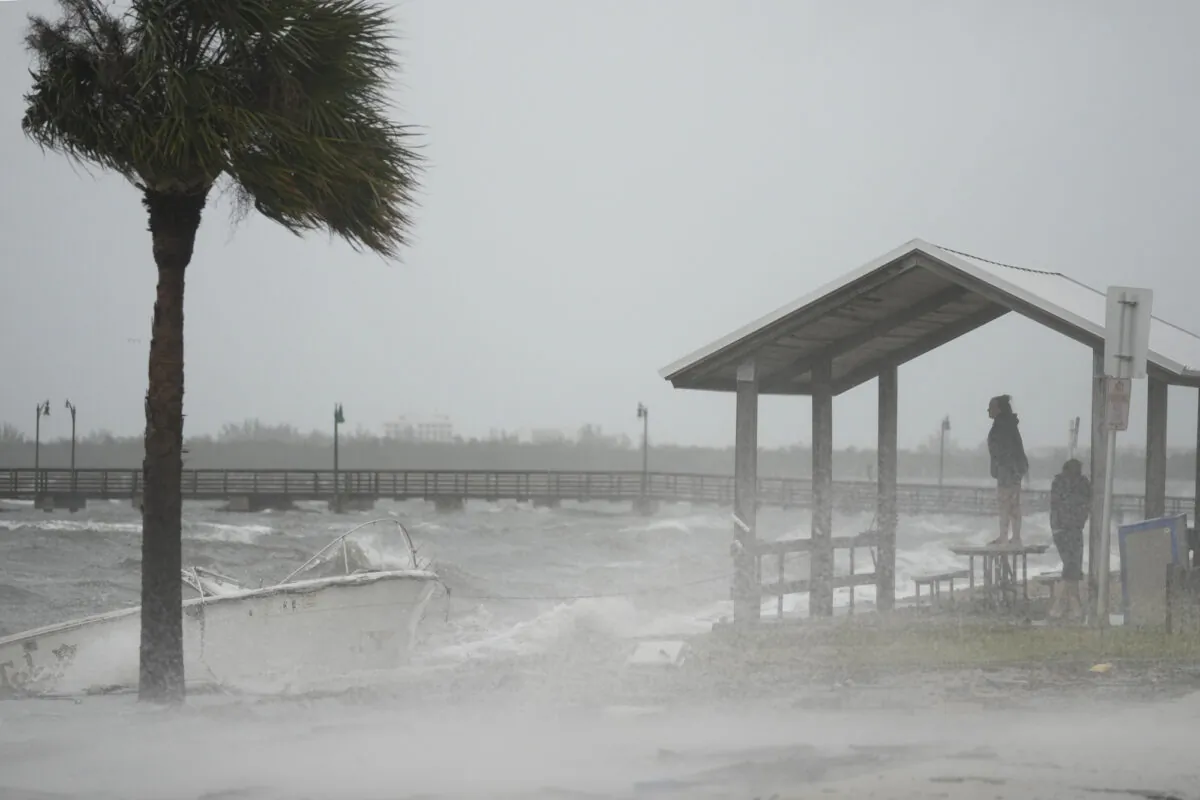 People brave rain and heavy winds to visit the waterfront along the Jensen Beach Causeway, as conditions deteriorate with the approach of Hurricane Nicole, in Jensen Beach, Fla., on Nov. 9, 2022. (Rebecca Blackwell/AP Photo)