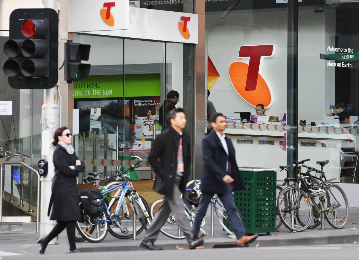A Telstra logo is seen as pedestrians walk outside the Telstra headquarters in Melbourne, Australia, on June 14, 2017. (Michael Dodge/Getty Images)