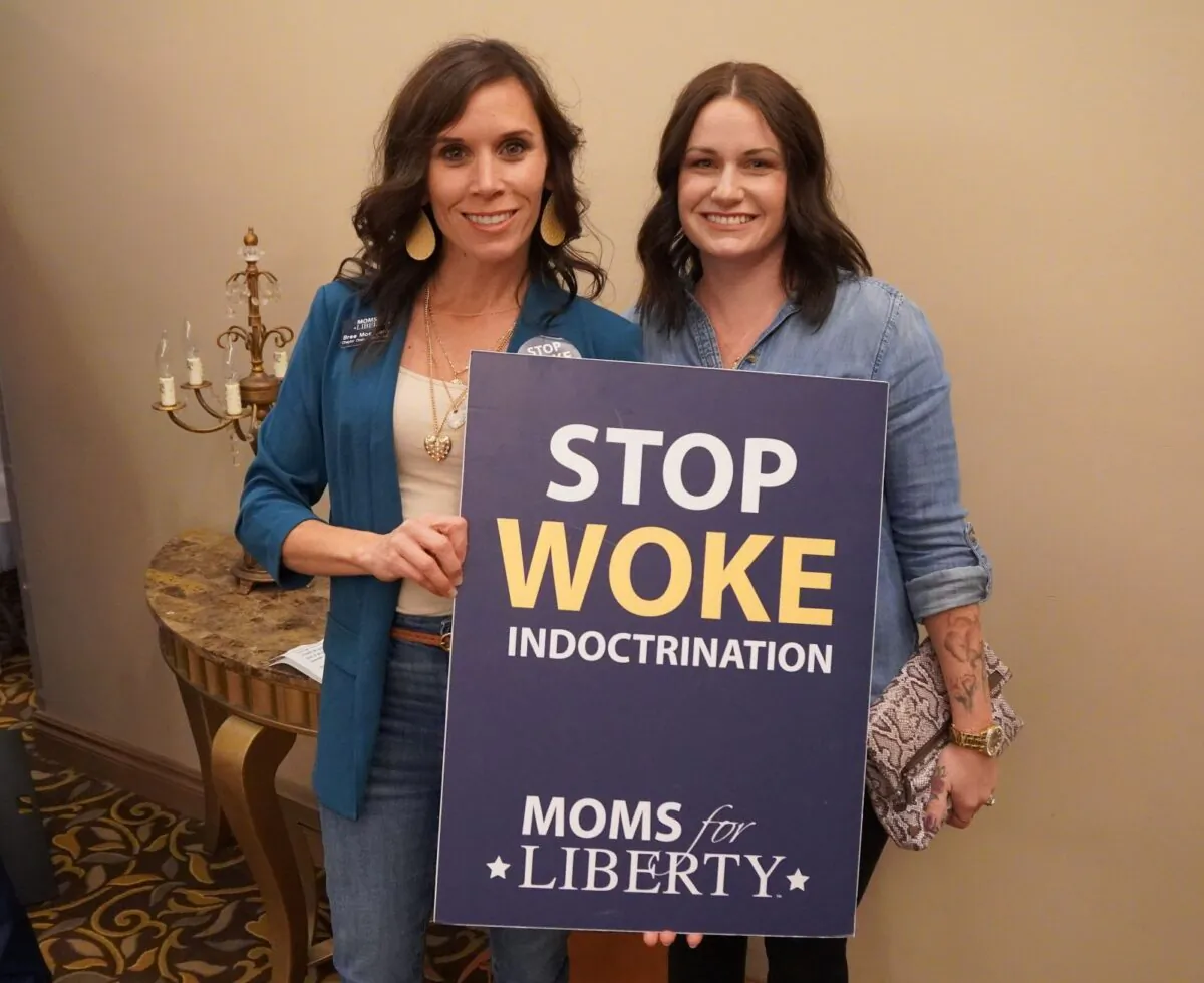 A mother and daughter protest woke ideology at a Moms for Liberty rally in Troy, Mich., on Oct. 14, 2022. (Steven Kovac/The Epoch Times)