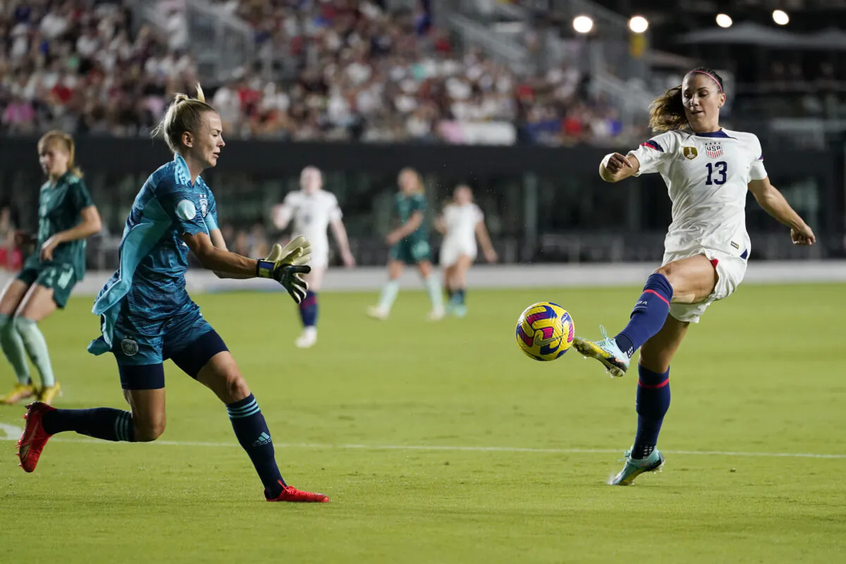 U.S. forward Alex Morgan (13) attempts a shot on the goal as Germany goalkeeper Merle Frohms defends an international friendly soccer match,  in Fort Lauderdale, Fla., on Nov. 10, 2022. (Lynne Sladky/AP Photo)