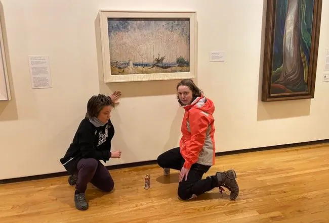 Climate activists with the group Stop Fracking Around threw maple syrup on Emily Carr’s 1934 painting “Stumps and Sky” and glued their hands to the wall under the painting at the Vancouver Art Gallery in Vancouver on Nov. 12, 2022. (Via Stop Fracking Around, Twitter)